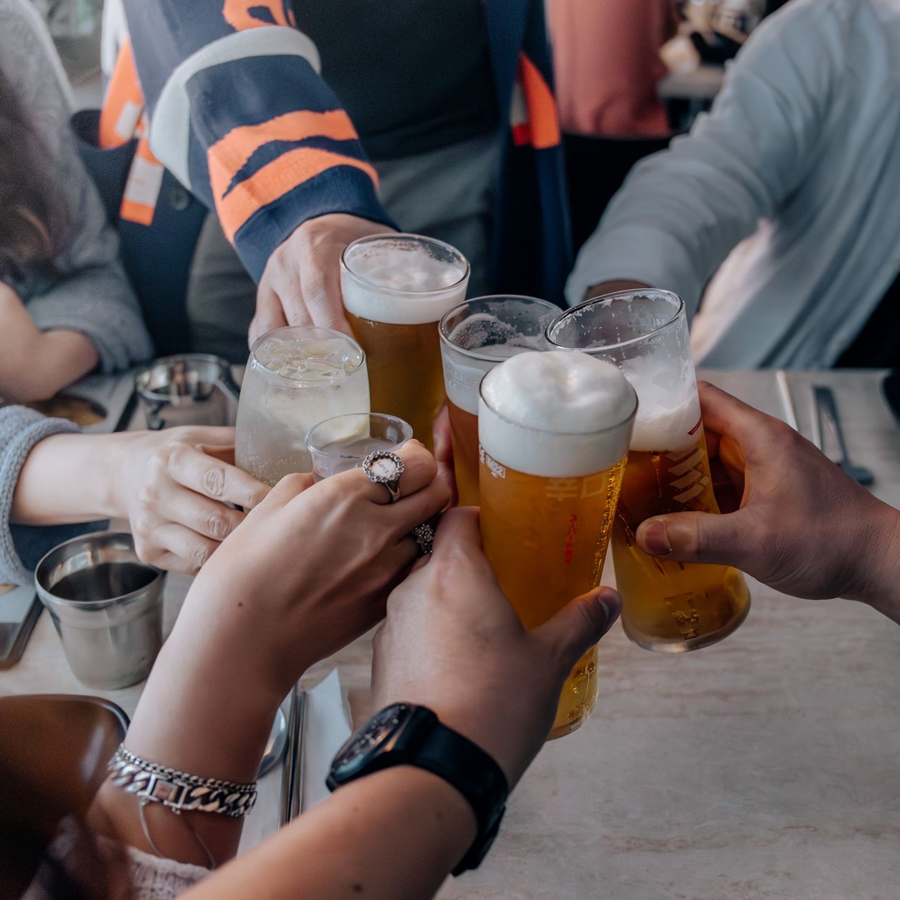 group of friends toasting with drinks at table